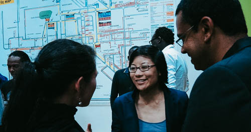Three Amani Institute fellows speaking to each other in a small room