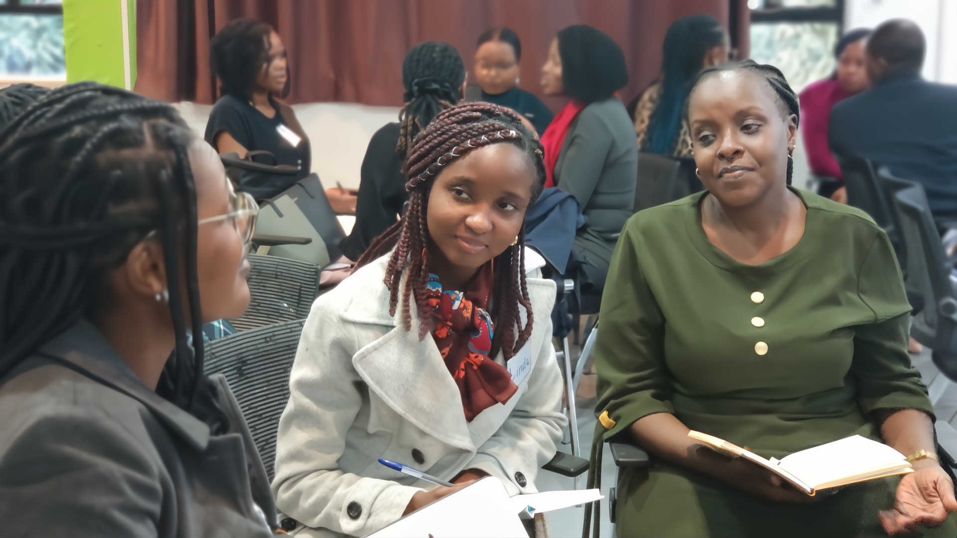 3 ladies having a conversation with other groups of people in the background